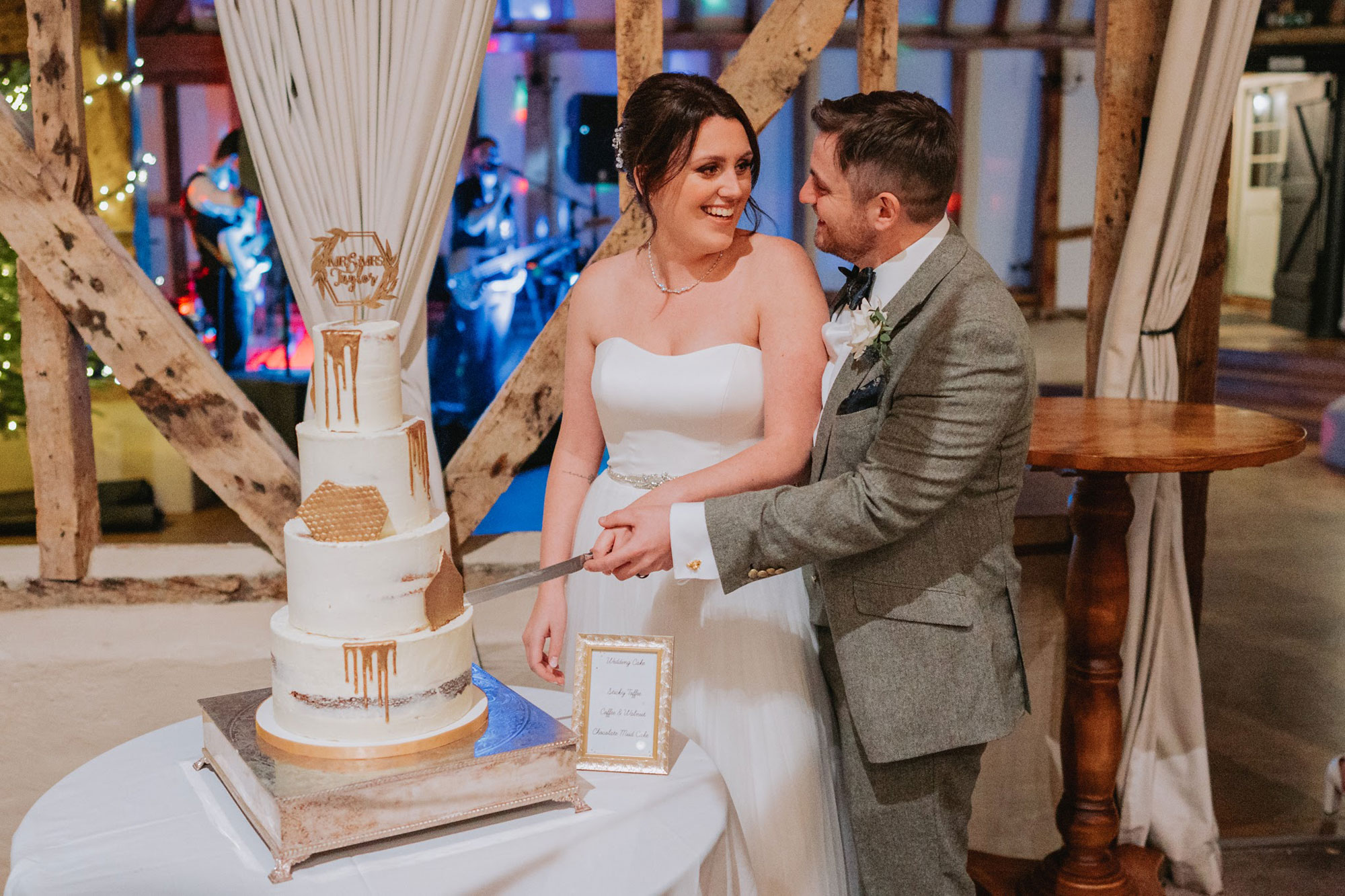 Bride and Groom cutting a 4 tier buttercream wedding cake with gold drips and gold shards | Louise Hayes Cake Design