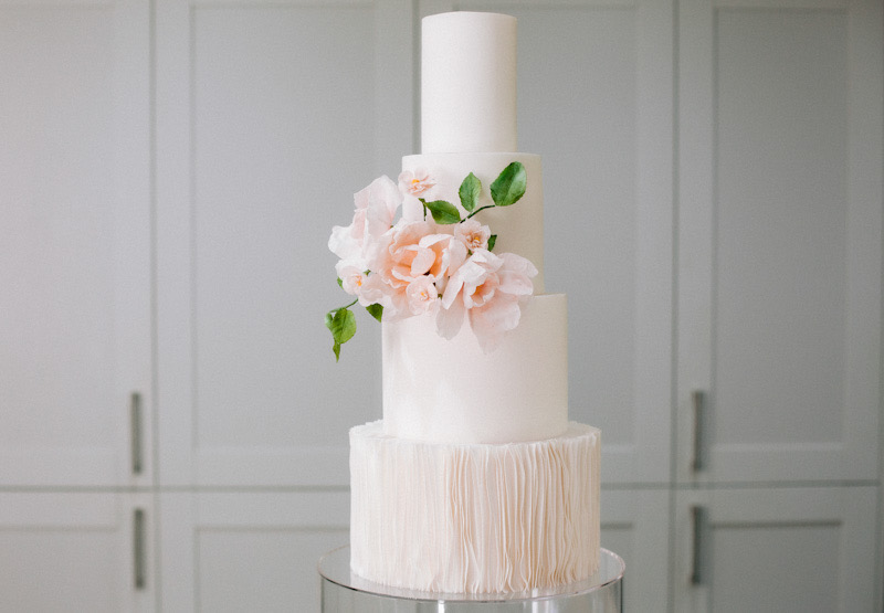 4 tier modern white wedding cake with ruffles and sugar flowers | Louise Hayes Cake Design | Photo by Meghan Claire Photography