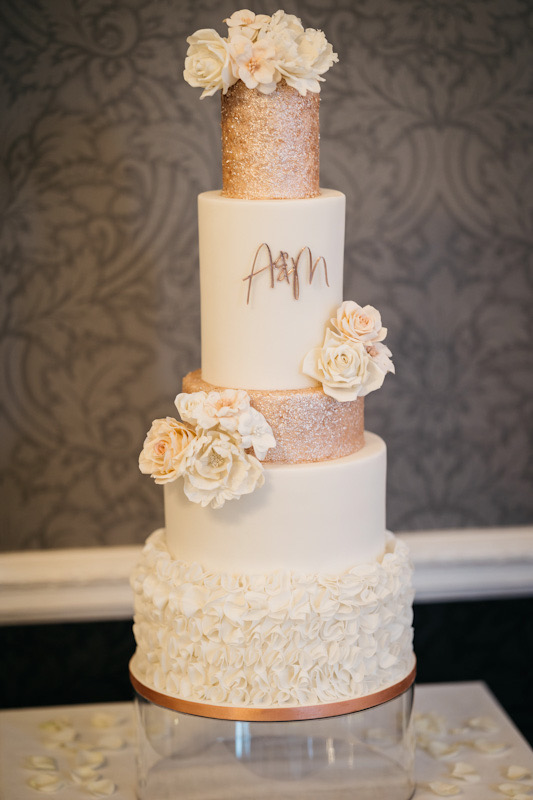 Show-stopper 5 tier white and rose gold blush wedding cake with ruffles, edible glitter and sugar flowers | Berkshire Mansion House wedding, Easthampstead Park | Chris Kemp Photography | Louise Hayes Cake Design