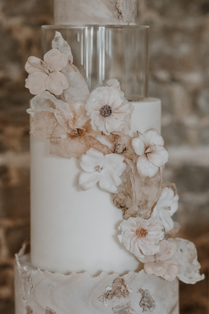 Nude, blush 3 tier contemporary wedding cake with wafter paper sails and sugar flowers | Louise Hayes Cake Design | Melissa Megan Photography | Cowdray Wedding