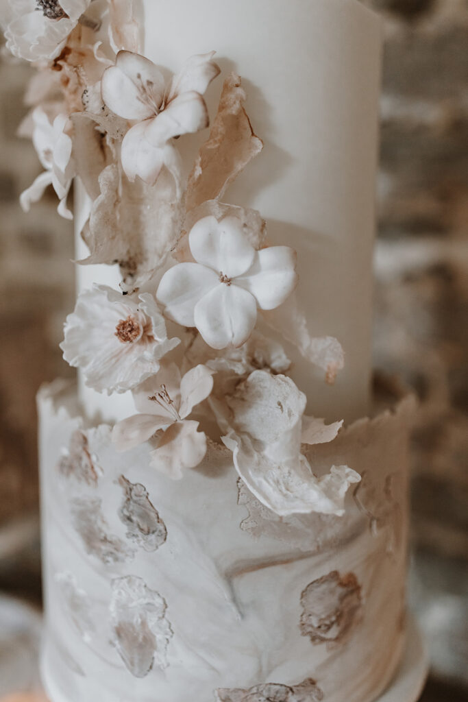 Nude, blush 3 tier contemporary wedding cake with wafer paper sails and sugar flowers | Louise Hayes Cake Design | Melissa Megan Photography | Cowdray Wedding