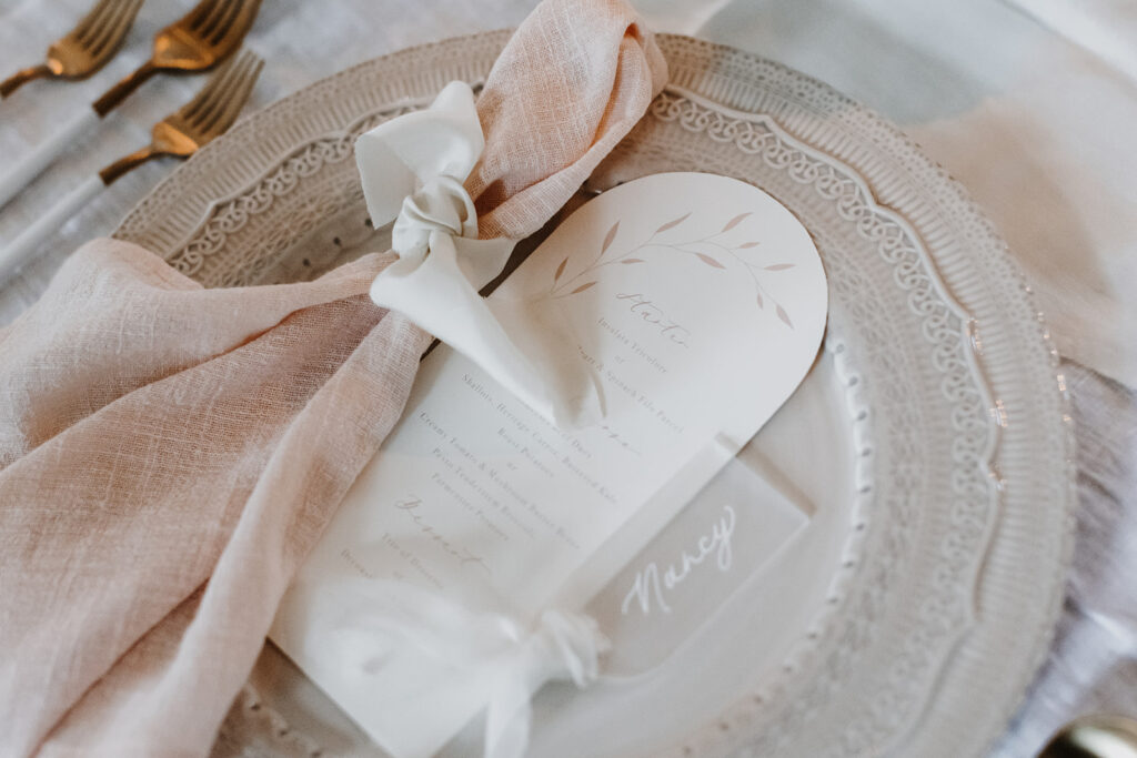 Close up of elegant stationery, blush napkin with silk ribbon and acrylic name card | Louise Hayes Cake Design | Melissa Megan Photography | Cowdray Wedding